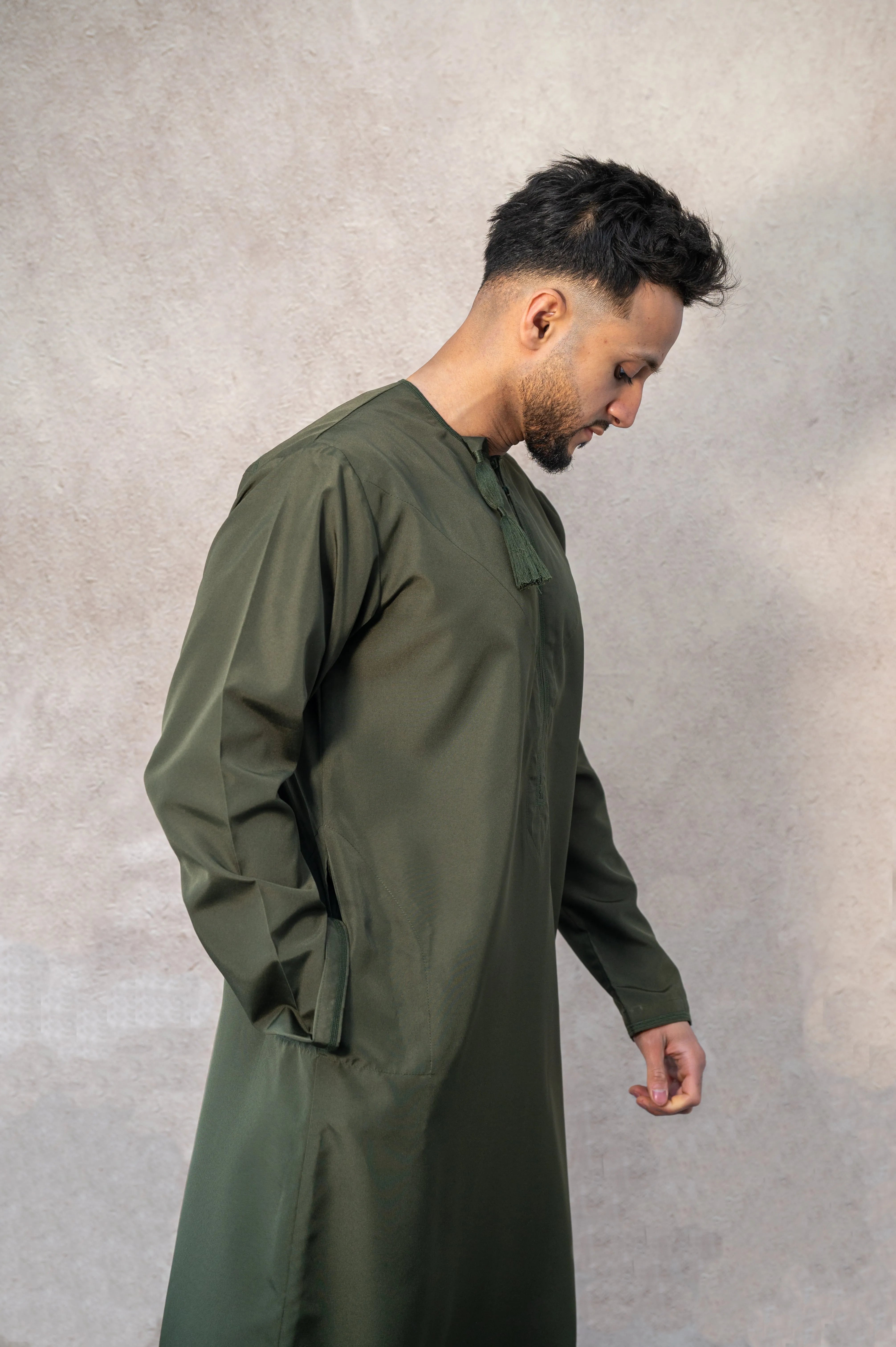 Side profile of forest green / Olive green Omani thobe / jubba showcasing relaxed fit
