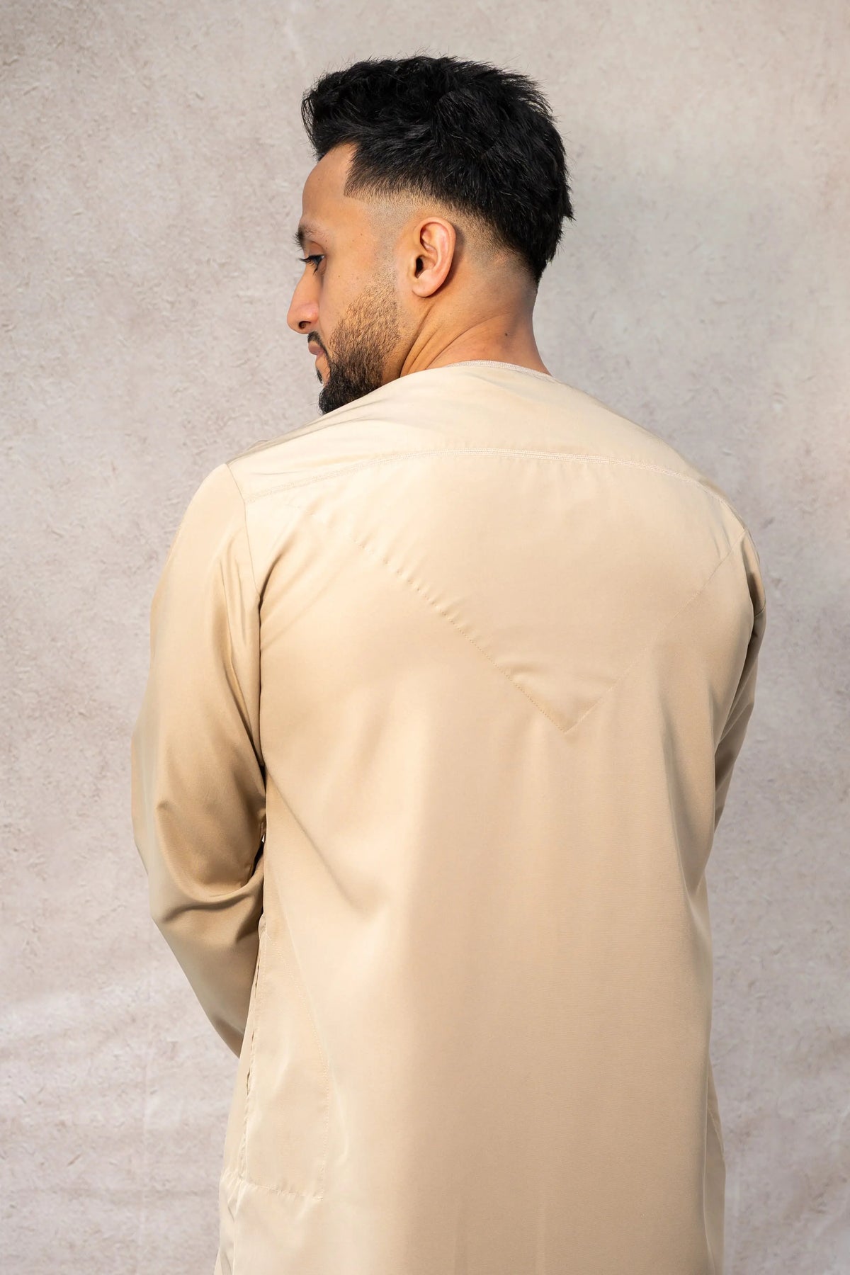 Back view of men’s sand/cream beige-colored Omani thobe / jubba showcasing smooth fabric and clean design.
