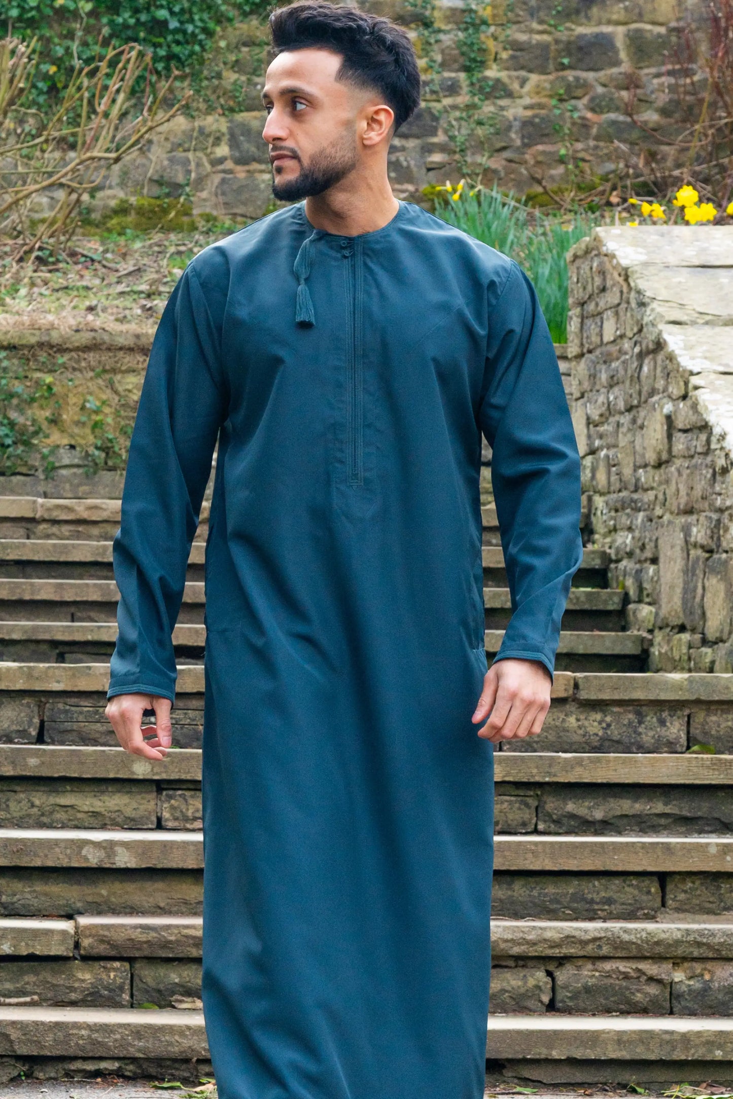 Omani Thobe / Jubba in teal blue shown in natural lighting outdoor