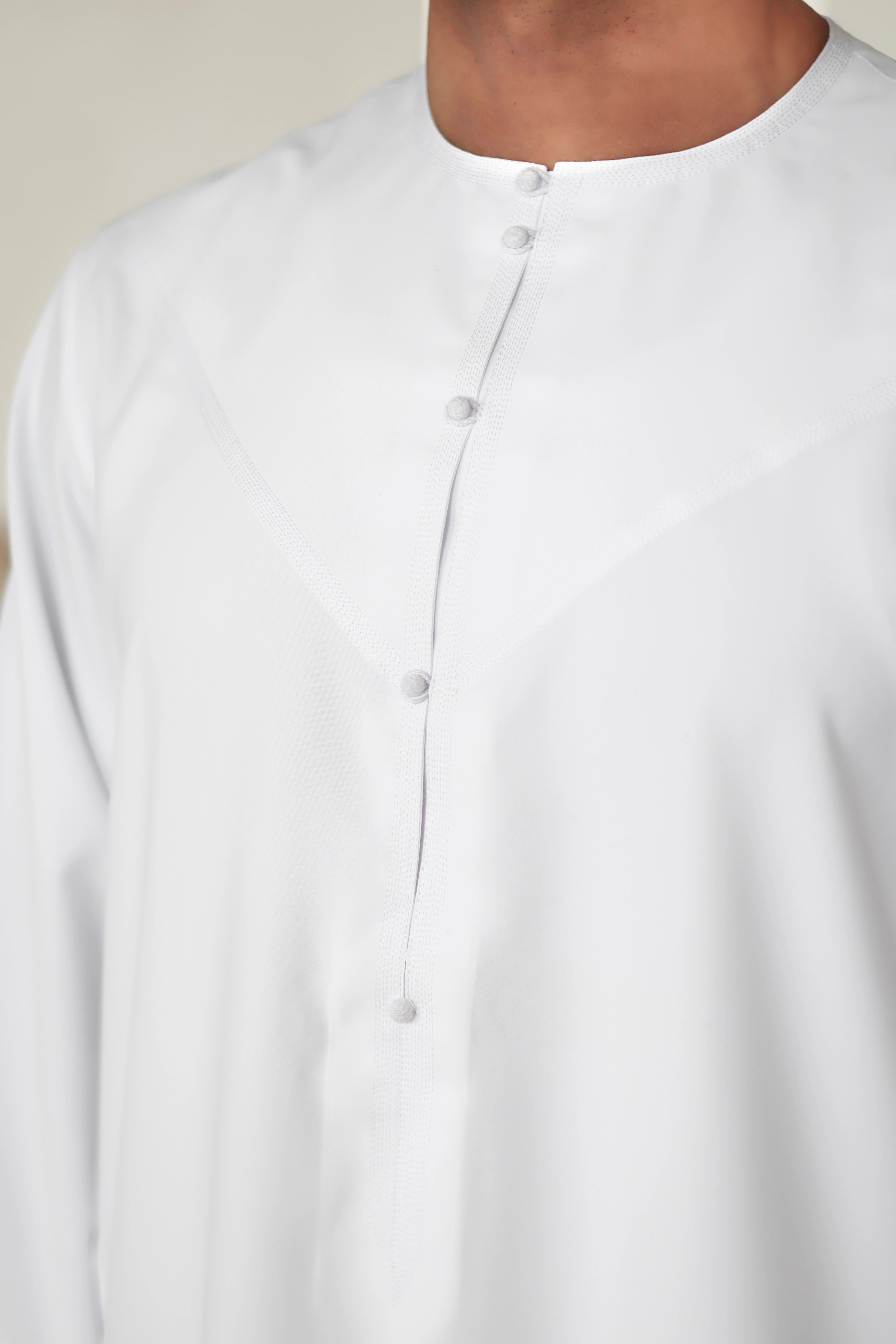 close-up of hand stitched buttons on QALBI Emirati thobe