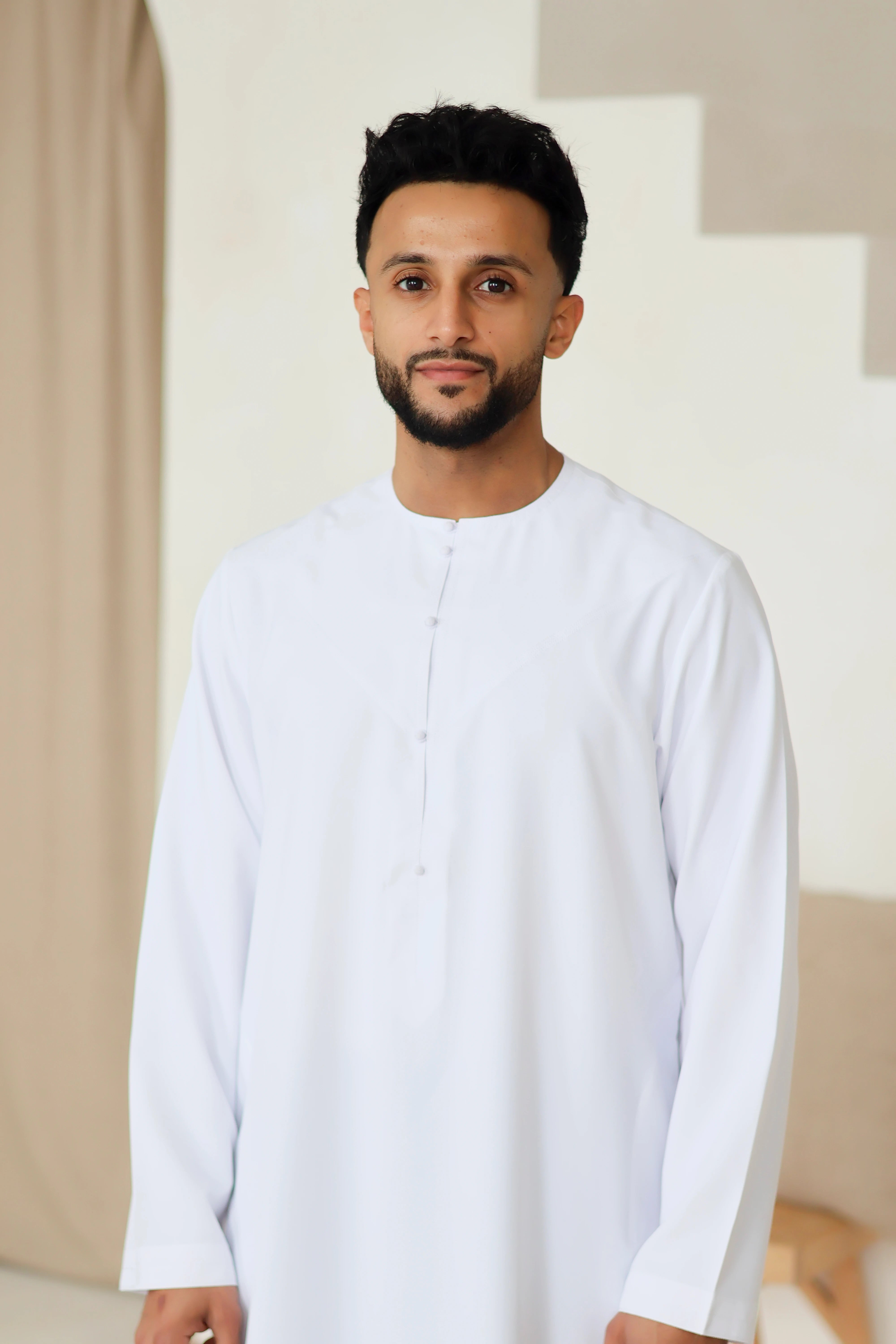 white Emirati thobe by QALBI with hand stitched buttons